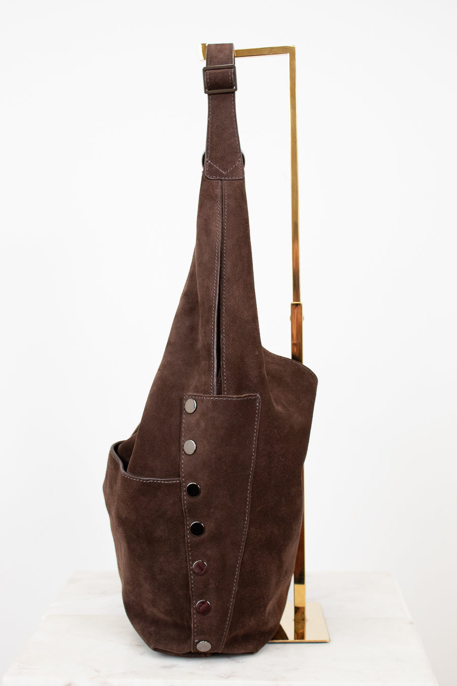 Brown leather hobo bag with buttons on a white background