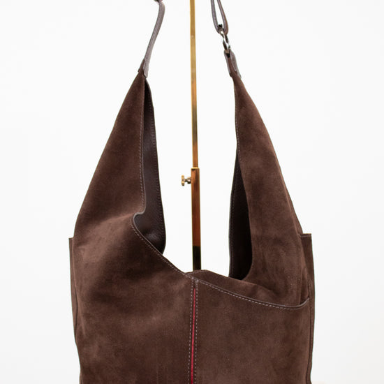 Brown suede handbag with a strap on a white background