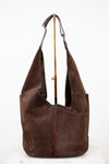 Brown suede handbag with a strap on a white background