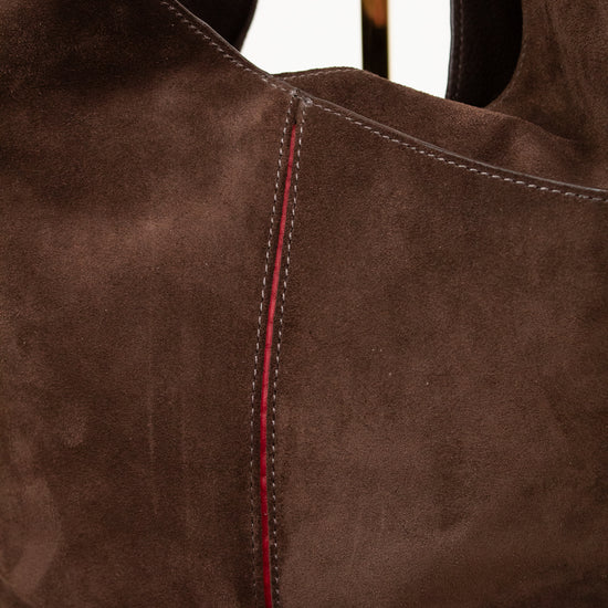 Brown suede handbag with red stitching on a white background