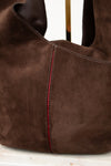 Brown suede handbag with red stitching on a white background