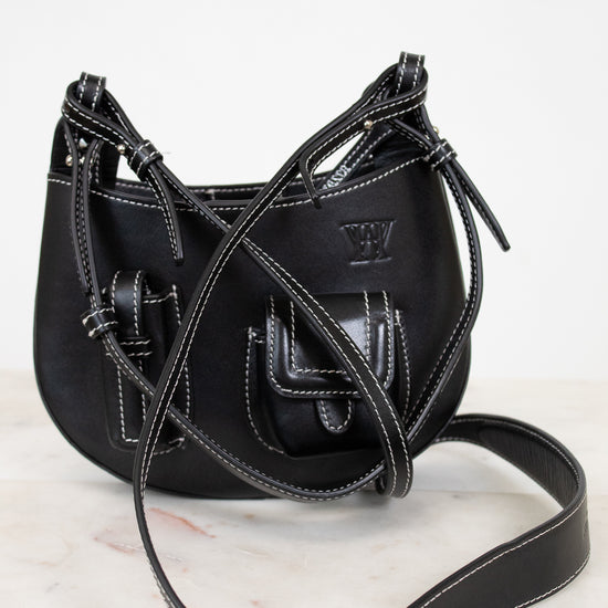 Black leather handbag with a strap on a white background