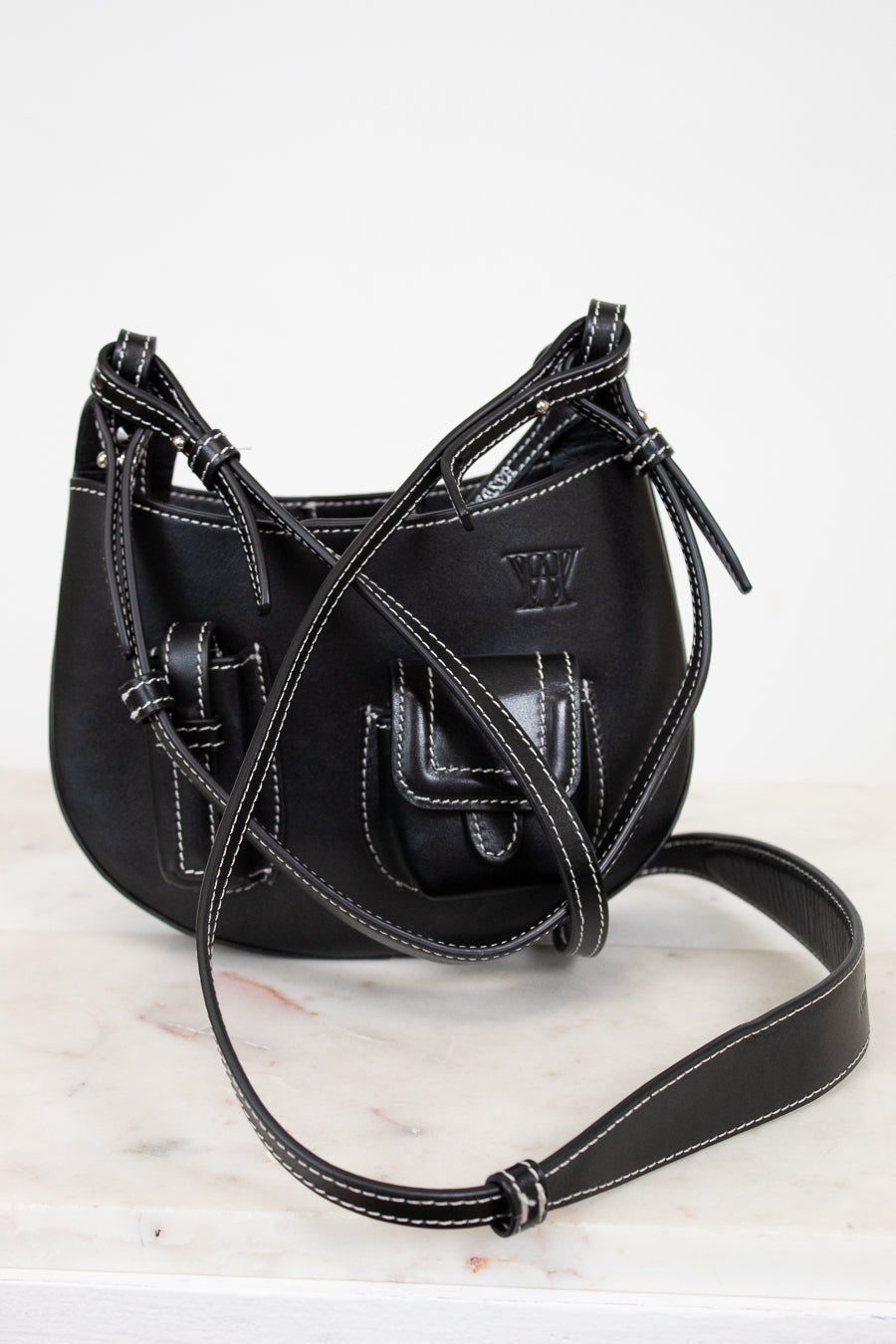 Black leather handbag with a strap on a white background