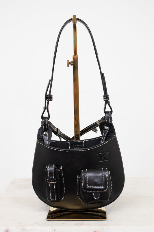 Black leather handbag on a stand against a white background