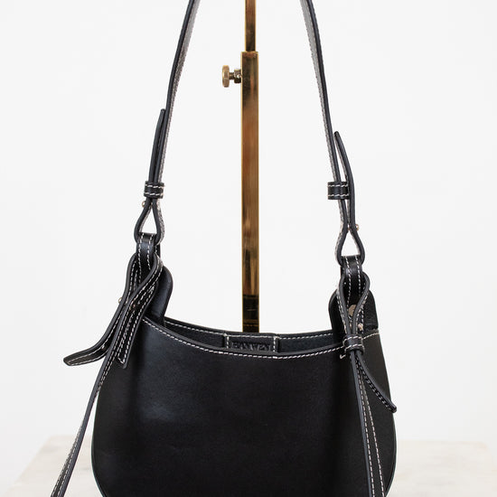Black leather handbag with a strap on a white background