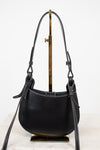 Black leather handbag with a strap on a white background