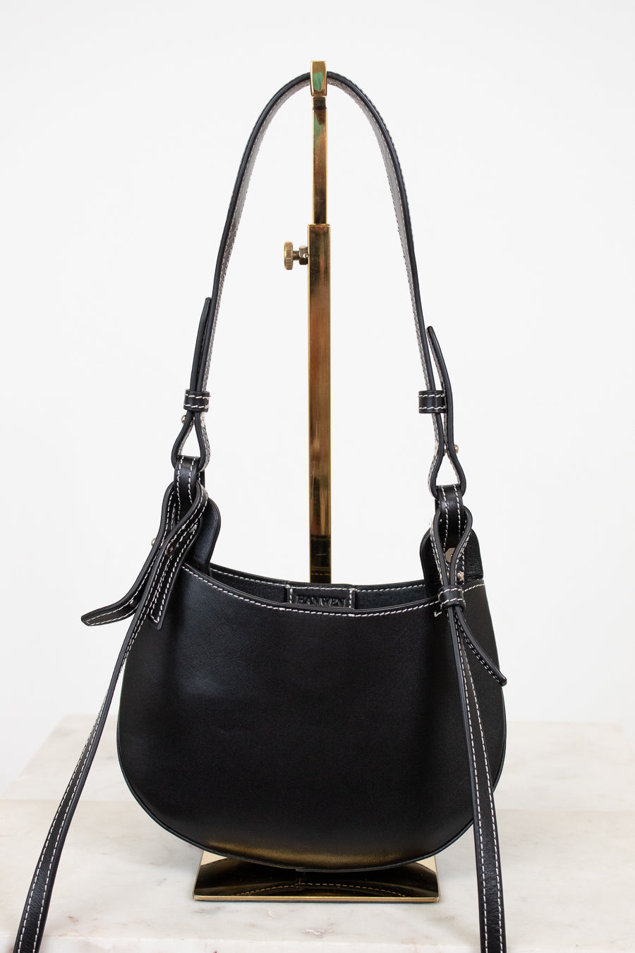 Black leather handbag with a strap on a white background