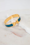 Teal and gold bracelet with H clasp on white background