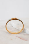 Gold bracelet on a marble surface with a light gray background