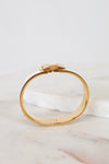 Gold bracelet on a marble surface