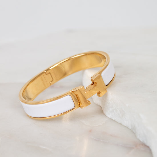 Gold and white bracelet on a marble surface