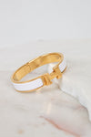 Gold and white bracelet on a marble surface