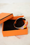 Bangle in an open orange box on a marble surface