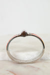 Silver bracelet with hinge on a marble surface