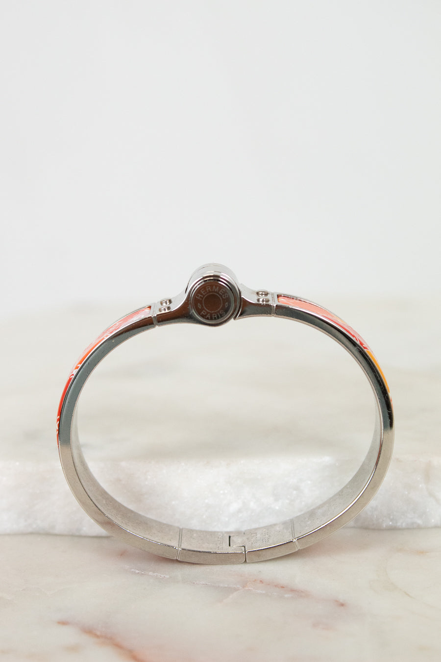 Silver bracelet with hinge on a marble surface