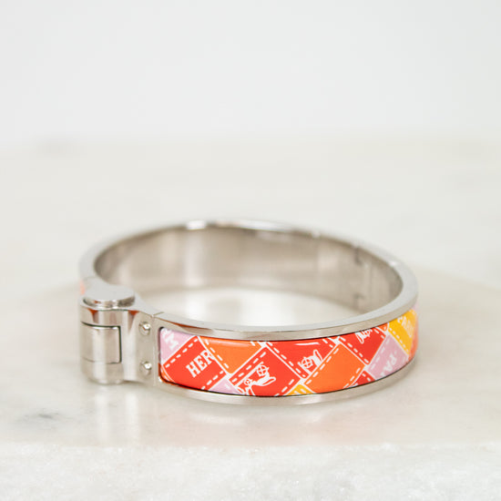 Silver bracelet with a colorful band on a white marble surface