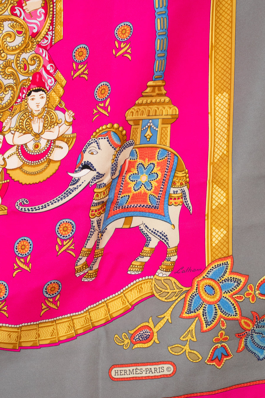 Colorful scarf with elephant design and Hermès Paris logo on a pink and gray background