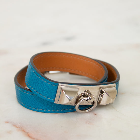 Blue leather bracelet with silver clasp on a marble surface