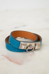 Blue leather bracelet with silver clasp on a marble surface
