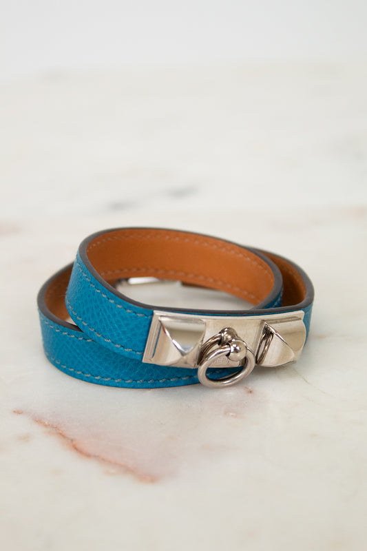 Blue leather bracelet with silver clasp on a marble surface