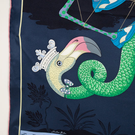 Silk scarf with a colorful bird design on a dark blue background
