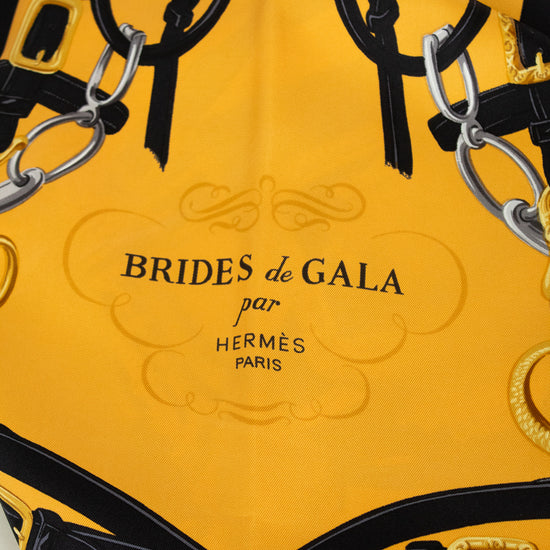 Yellow and black scarf with 'Brides de Gala par Hermès Paris' branding.