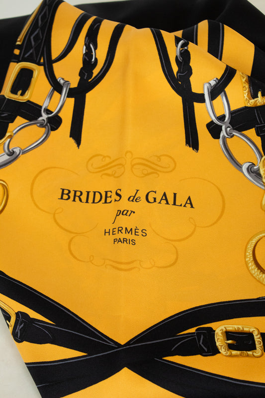 Yellow and black scarf with 'Brides de Gala par Hermès Paris' branding.