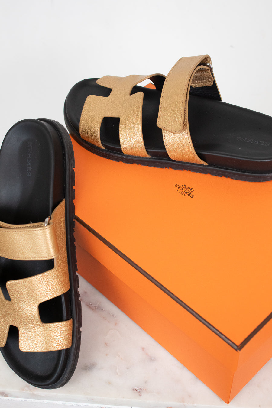Gold and black sandal on orange 'Hermes' box