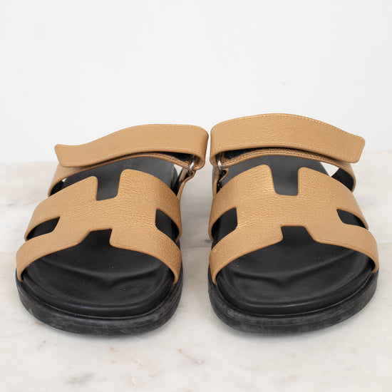Pair of black and gold sandals on marble surface