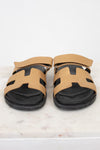 Pair of black and gold sandals on marble surface