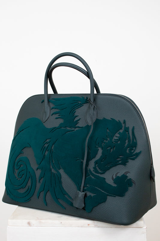 Black handbag with a dragon design on a white background