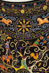 A close-up of a black textile scarf featuring a highly detailed, colorful folk-art print with horses, parrots, a rooster, floral motifs, and swirling gold lines. The text 'Peuple du Vent' is printed across the center wheel.