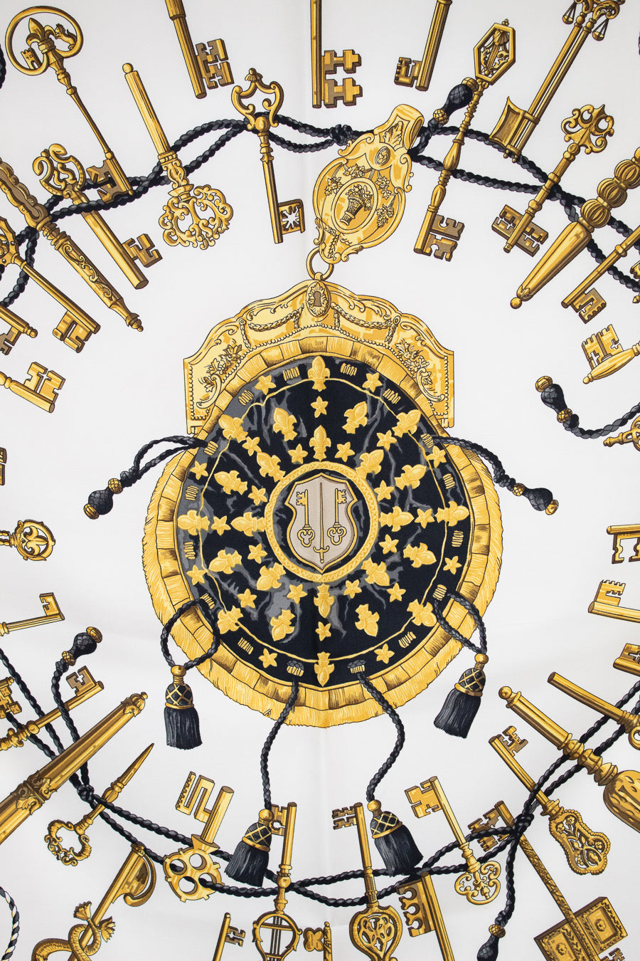 Decorative design with gold keys and a central emblem on a white background