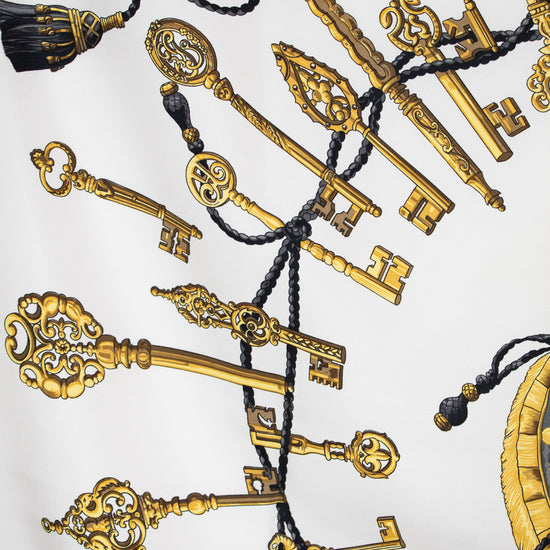 Decorative pattern of gold keys and tassels on a white background