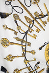 Decorative pattern of gold keys and tassels on a white background
