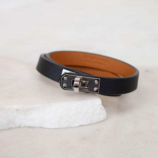 Black leather belt with silver buckle on a white surface