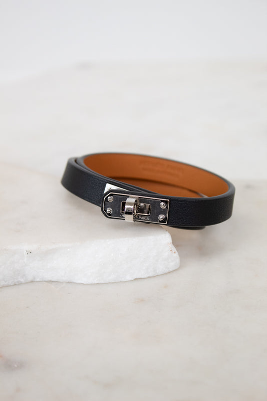 Black leather belt with silver buckle on a white surface