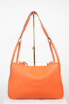 An orange pebbled leather shoulder bag with a gold-tone metal stand, photographed against a plain white background.