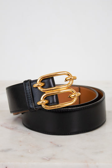 Black belt with a gold chain buckle on a light background