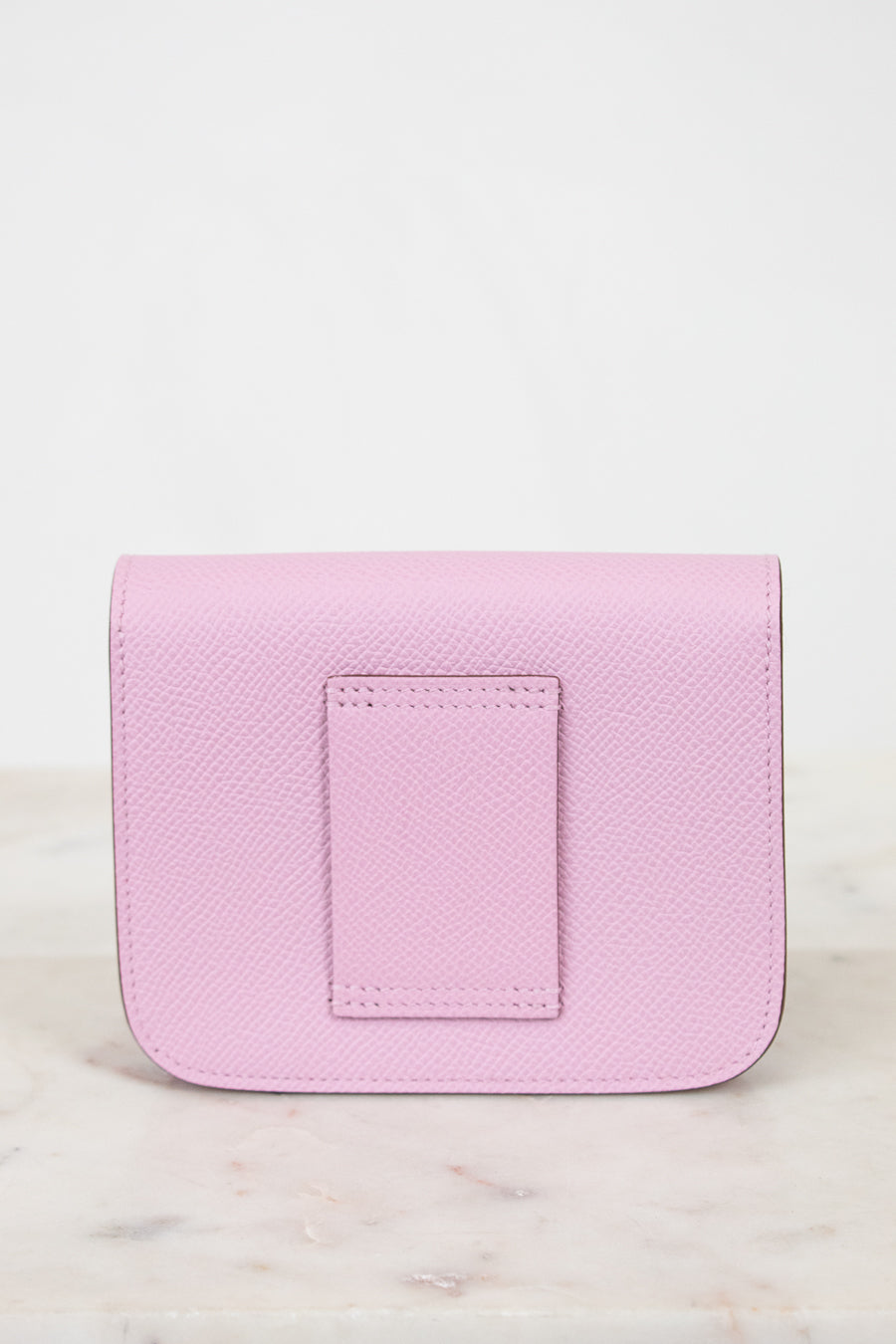Pink leather wallet on a light marble background