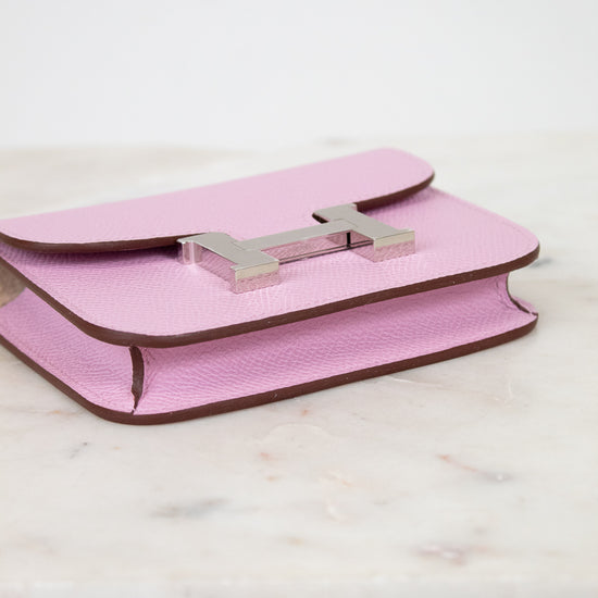 Pink handbag with a silver clasp on a light wooden surface