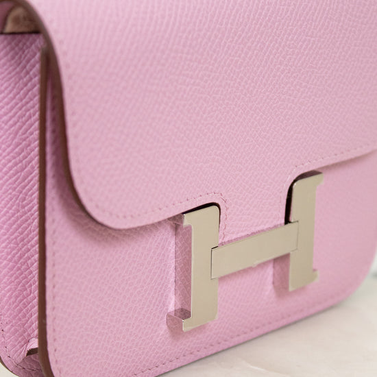 Pink handbag with a gold logo on a light background