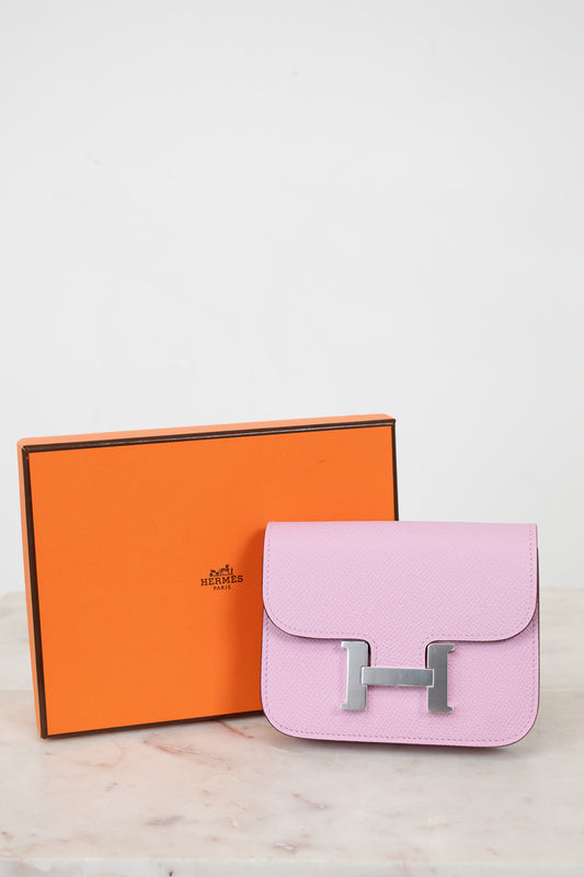 Pink handbag with silver hardware next to an orange Hermes box on a light background