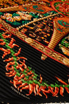 Hermès scarf with intricate design featuring peppers and braided patterns.