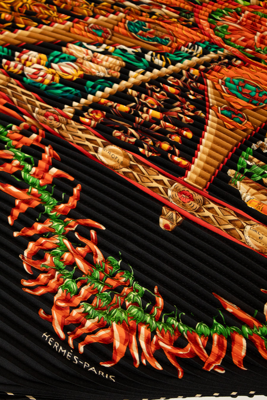 Hermès scarf with intricate design featuring peppers and braided patterns.