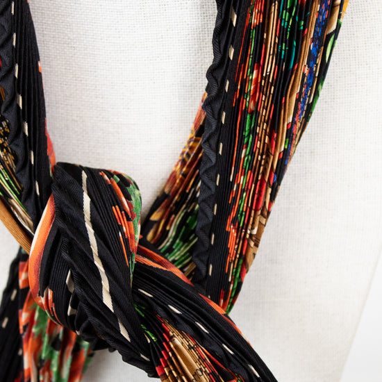 Colorful woven belt with a knot on a white background