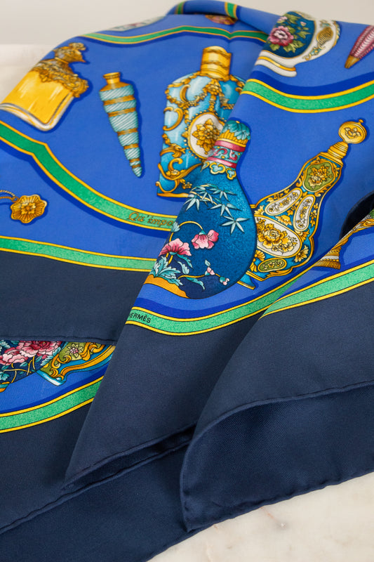 Decorative fabric scarf with intricate patterns and colors on a blue background