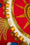 Close-up of a coat of arms with gold and red colors, featuring an eagle and a shield.