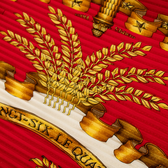 Close-up of a detailed coat of arms with gold elements on a red background