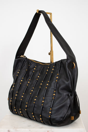 Black handbag with gold studs and accents on a white background